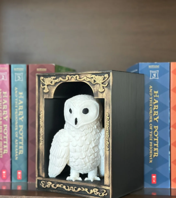 White owl figurine in a decorative box with 'Harry Potter' books in the background