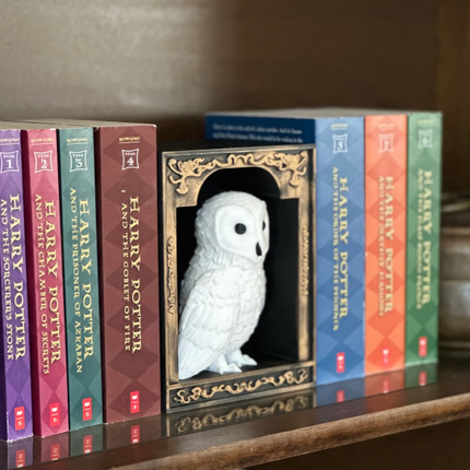 Collection of 'Harry Potter' books with a decorative owl figure in front